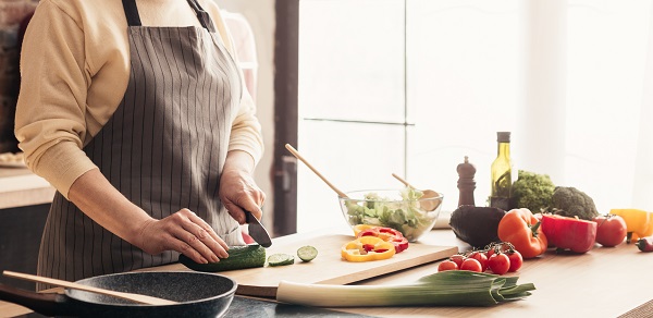 Senior woman cooking at kitchen, panorama, empty space